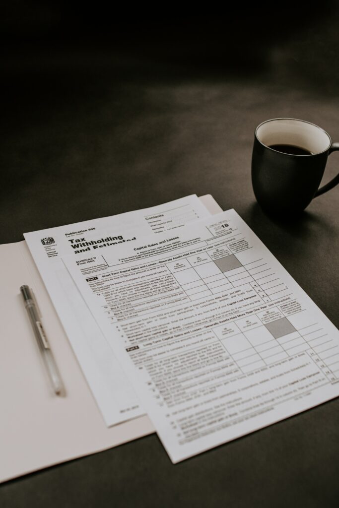 A cup of coffee sits alongside a tax form, specifically a PAYG Payment Summary, on a desk.