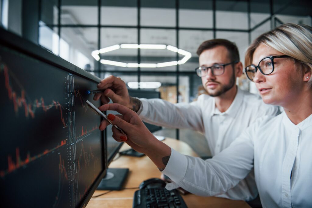 Two Business People Looking At A Computer Screen While Discussing &Quot;What Is Black Rock.