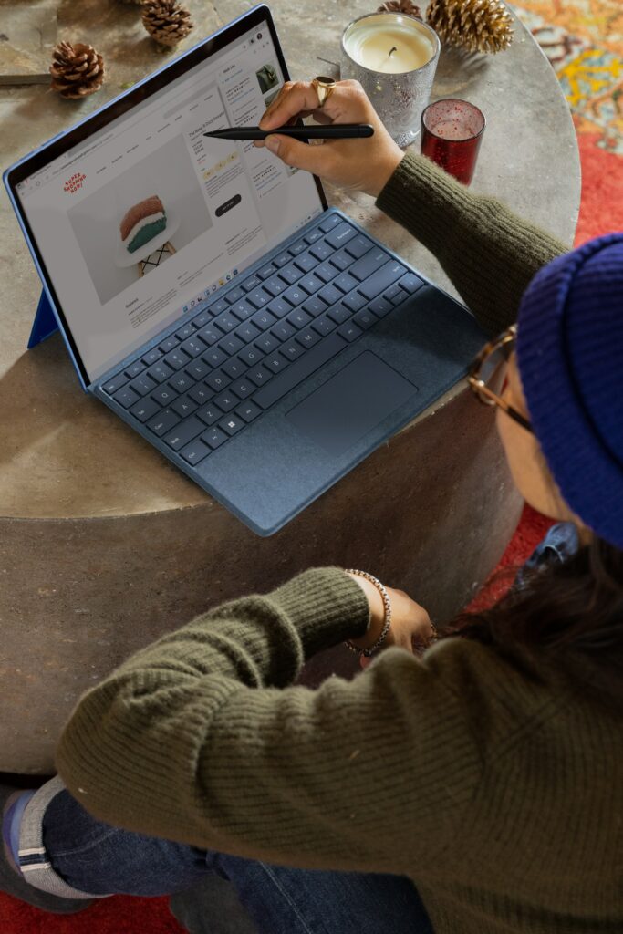 A woman leveraging a Microsoft Surface laptop for business marketing strategies.
